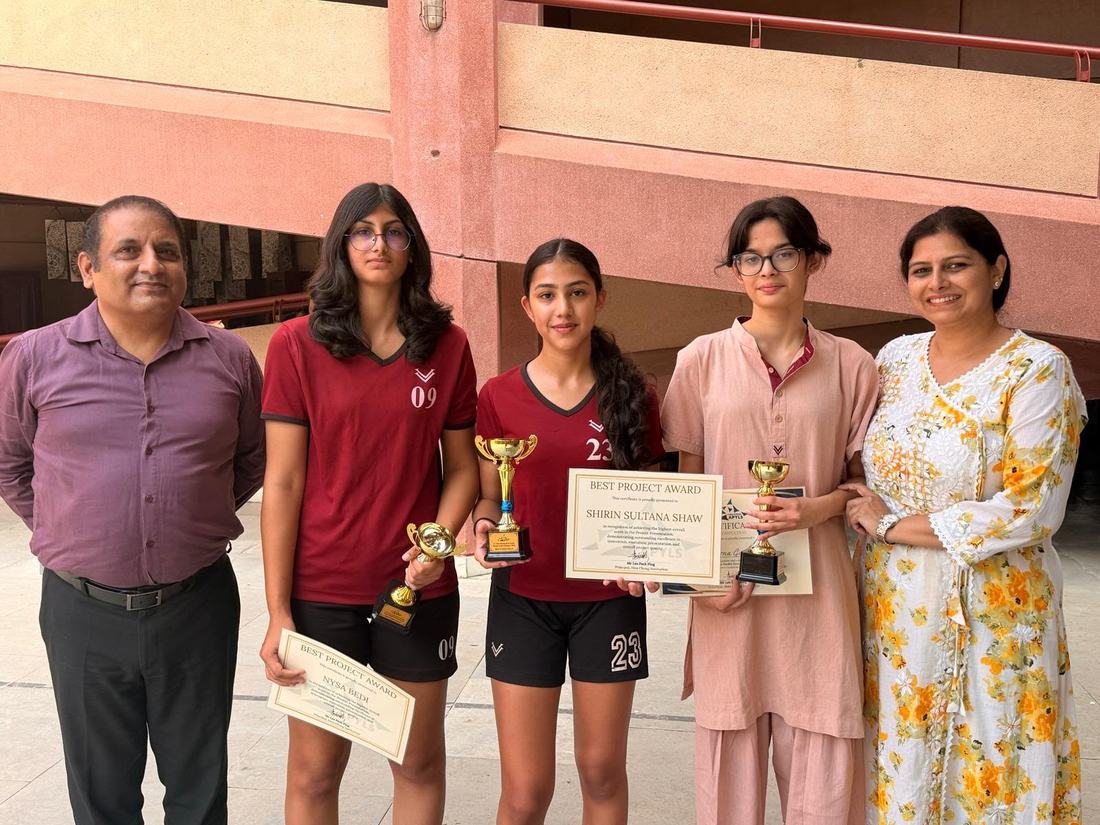 Nysa and two teammates with their trophies and certificates, standing with two teachers at Vasant Valley School